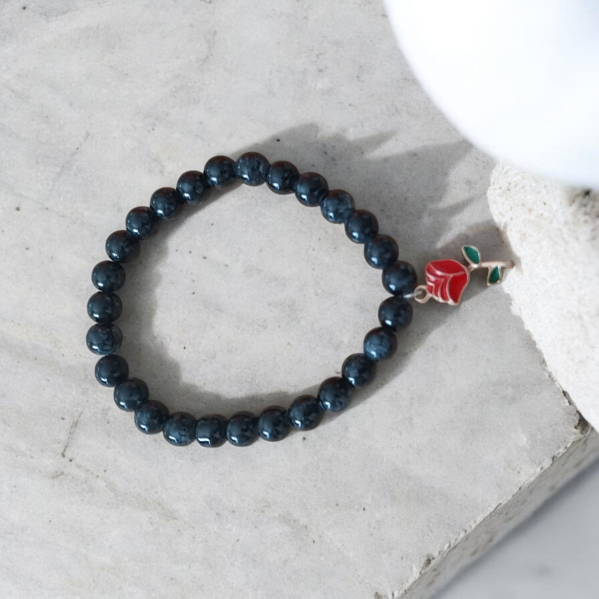 Onxy beaded bracelet with red flower charm
